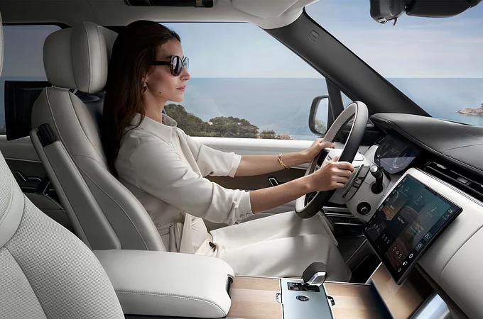 Woman driving Range Rover by the sea