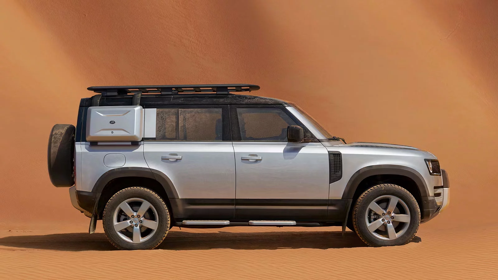 Defender 110 with explorer pack parked in the desert