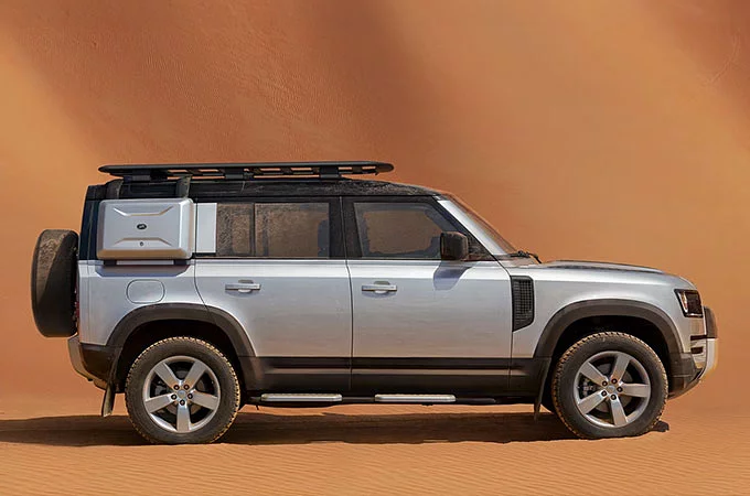 Defender 110 with explorer pack parked in the desert