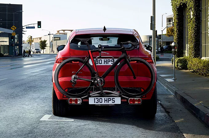 Jaguar E-PACE med hjulmonterad cykelhållare parkerad på en stadsväg