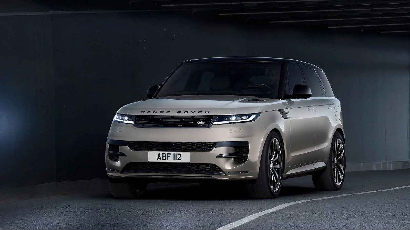 Range Rover Sport в цвете Borasco Grey, движущийся под мостом