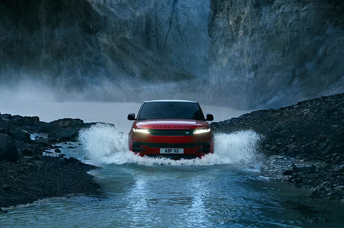 Range Rover Sport crossing water on the test road in forest area