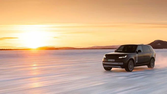 Range Rover brauc pa ceļu saulrieta laikā