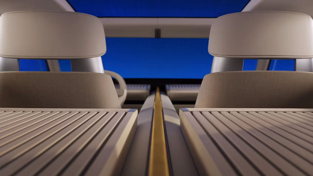 Vista interior de un coche que muestra los asientos y una consola central de madera sobre un fondo azul.