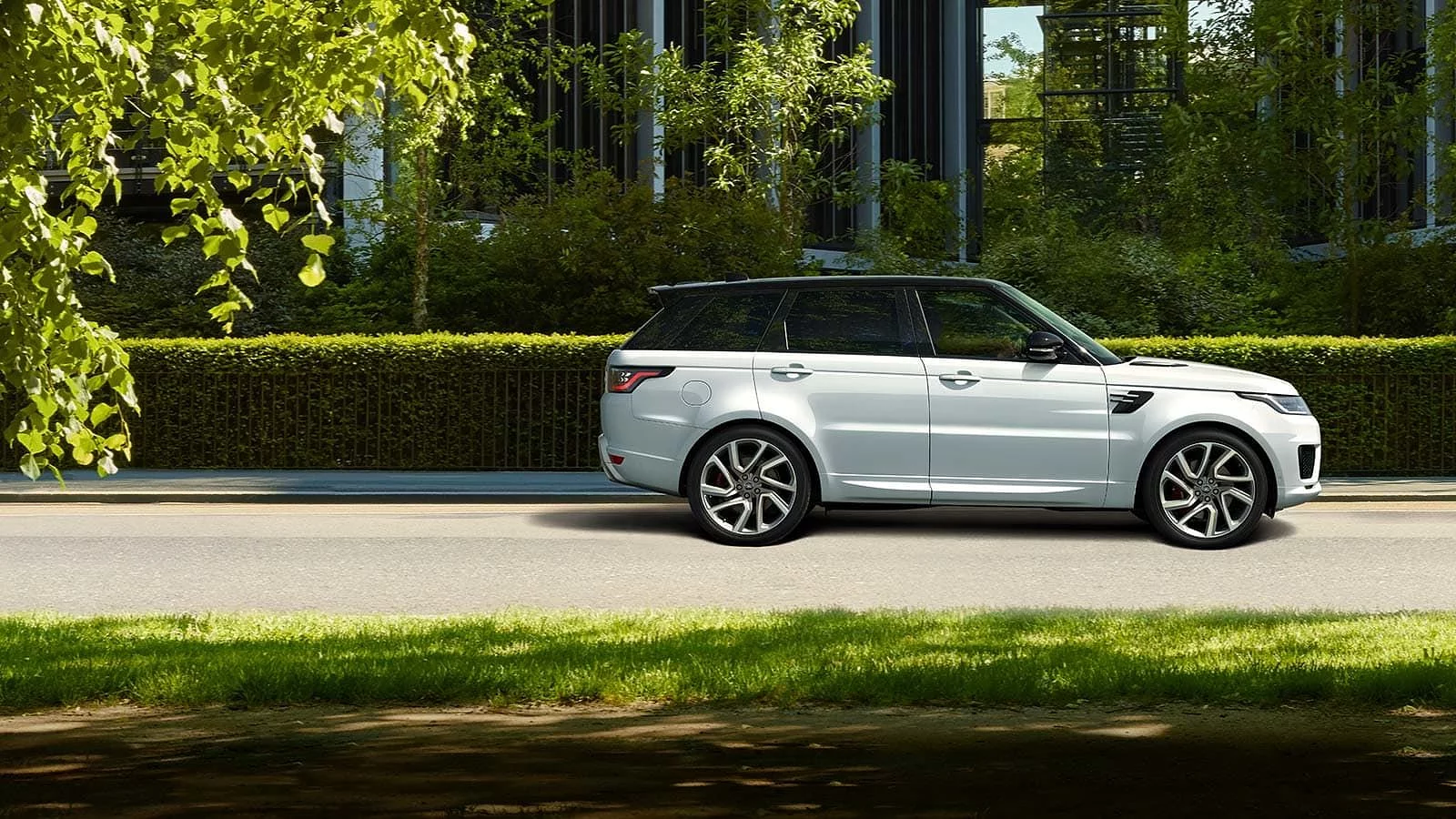 A luxury Range Rover Sport car driving on the street
