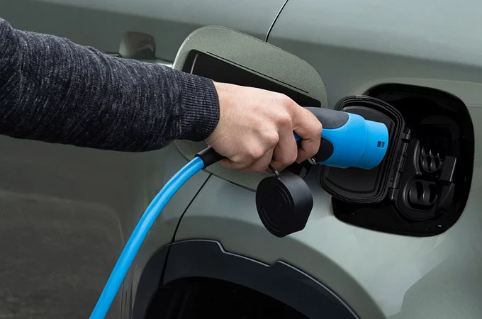 Man with inserting the charger in phev vehicle