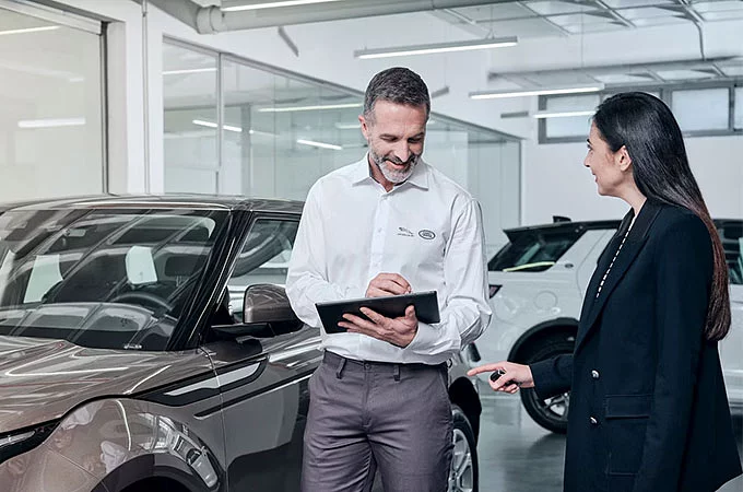 A sales person showing Land Rover Evoque in showroom